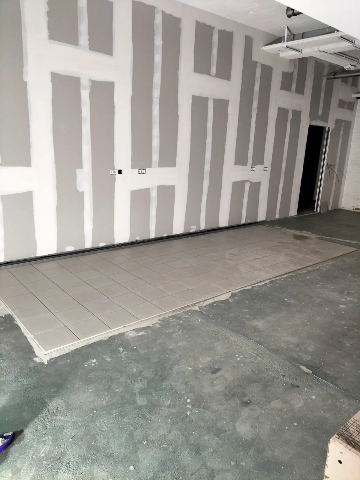 Interior renovation with drywall installation and tiled flooring